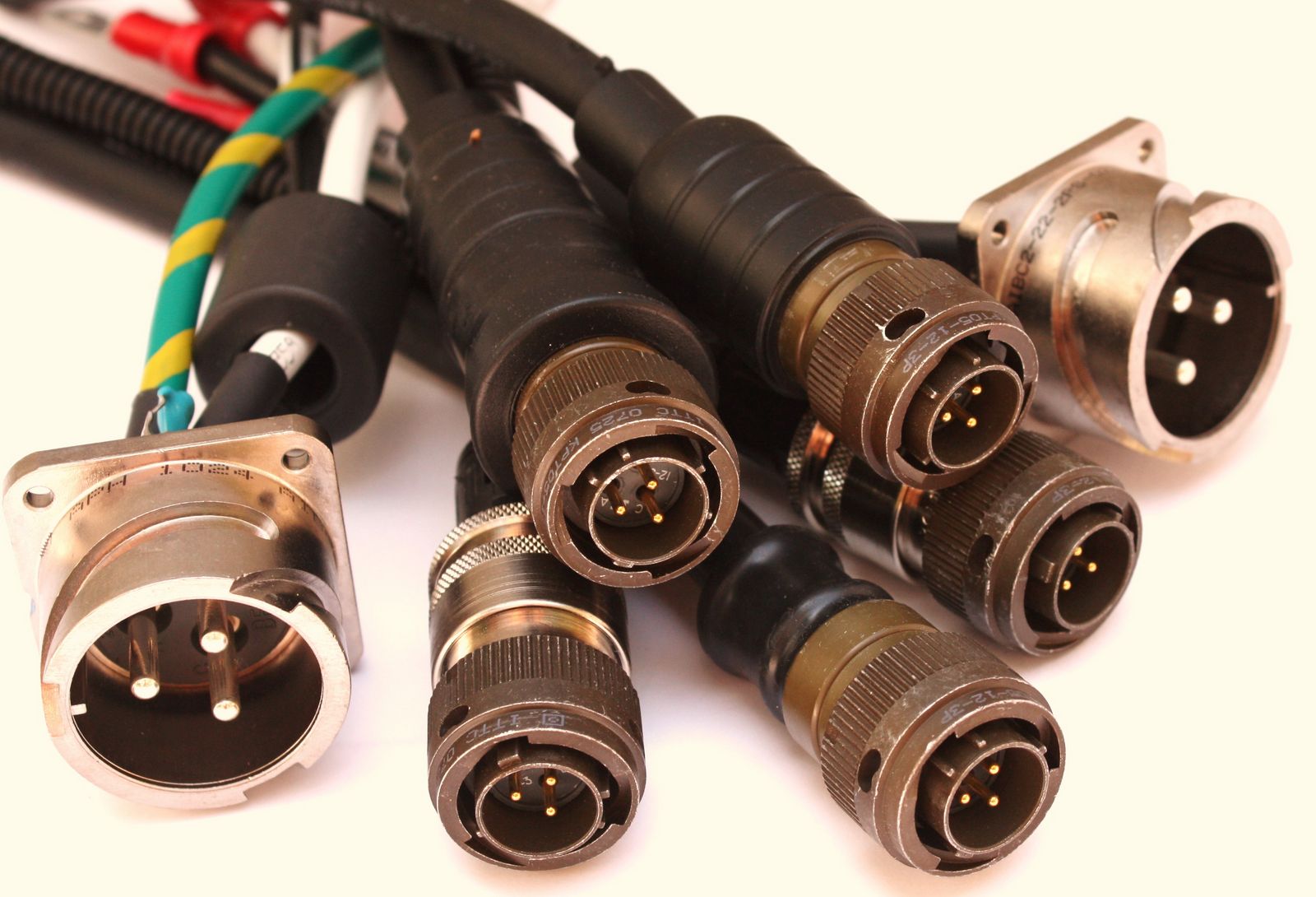 Black cable bundle with round metal connectors and exposed gold-colored pins