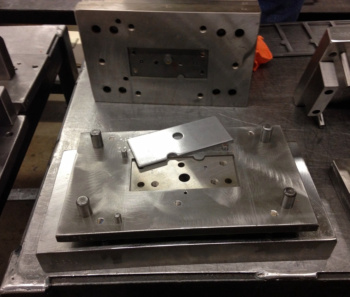 Tooling fixture with guide posts and a rectangular plate with a circular hole